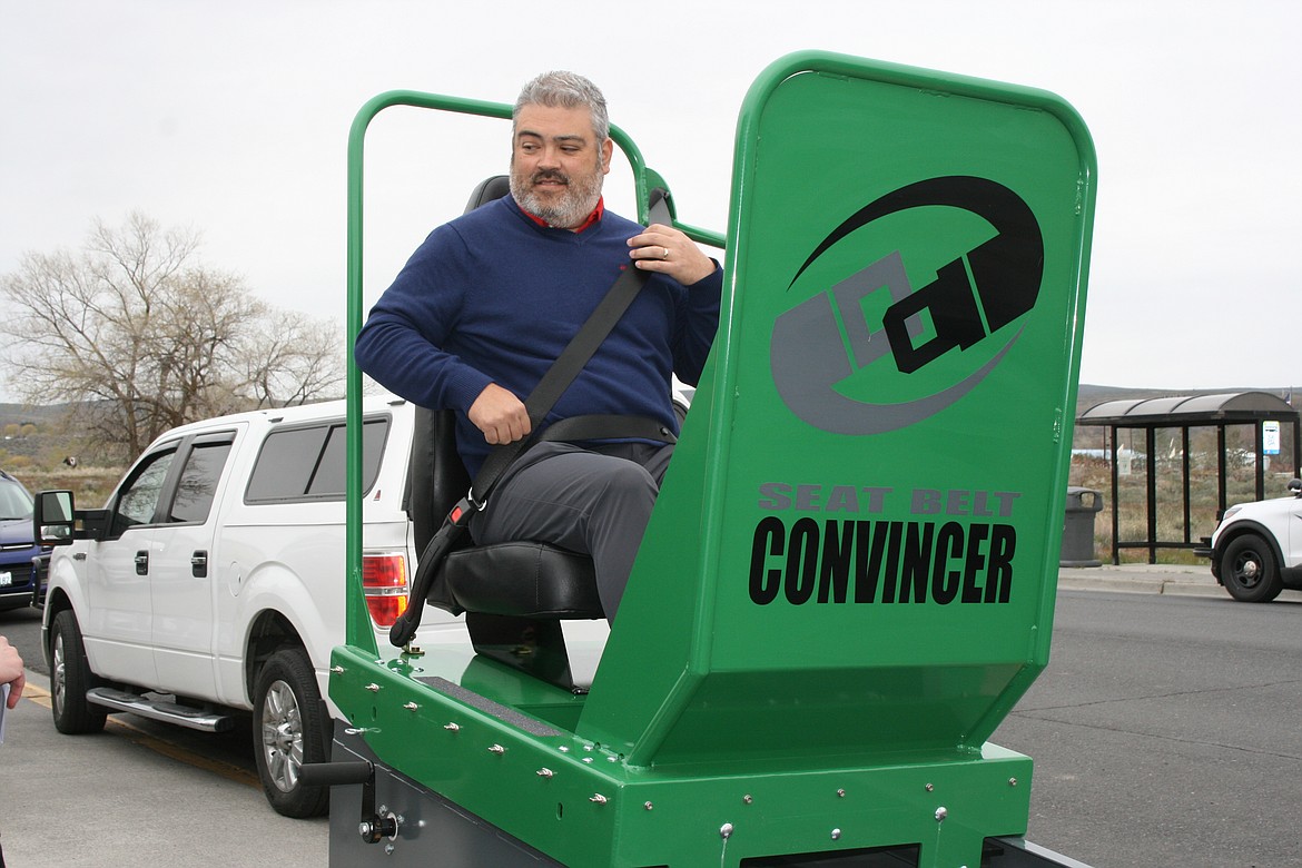 State Farm agent Cory Pickeral buckles himself into the Seatbelt Convincer during a demonstration Monday in Soap Lake. The equipment was purchased by the Target Zero program with the help of a grant from State Farm Insurance.