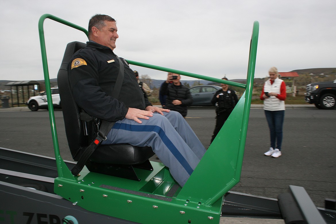 Washington State Patrol trooper John Bryant rides the Seatbelt Convincer, purchased with the help of a grant from State Farm Insurance and demonstrated in Soap Lake Monday.