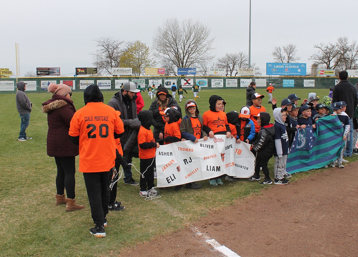 Players brave the cold to share their team spirit at the Dick Kelly Memorial Youth Day opening ceremony Saturday at Larson Playfield in Moses Lake. Twenty-five boys baseball and 25 girls softball teams held banners and signs at the event.