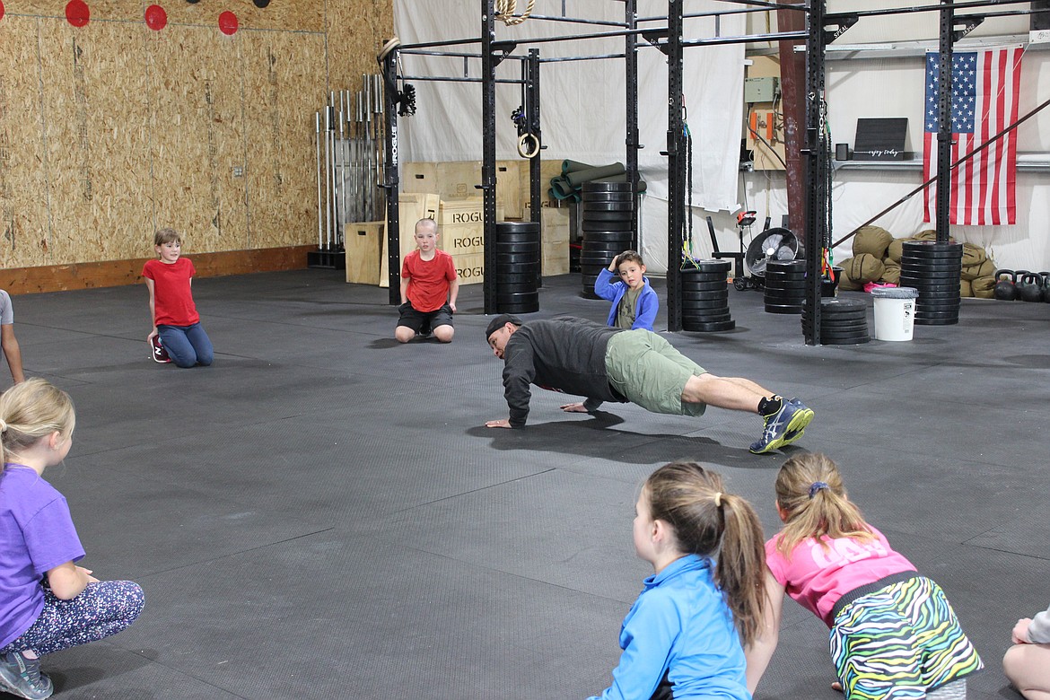 Steps of Justice Crossfit coach Jimmy Karlin shows the proper push-up technique. (Taylor Inman/Daily Inter Lake)