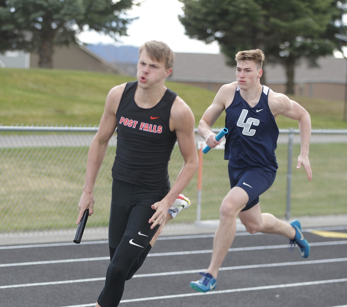 JASON ELLIOTT/Press
Post Falls senior Chase Berg and Lake City junior Zach Johnson take the baton for the final leg of the boys 4x200 relay at the Christina Finney Relays meet at Post Falls High on Tuesday. Lake City won the event in 1 minute, 31.62 seconds, followed by Post Falls in 1:31.93.