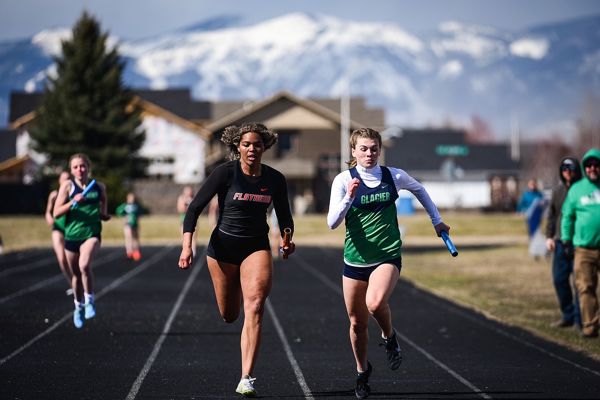 Flathead's Akilah Kubi and Glacier's Noah Fincher race toward the finish line in the girls 400 meter relay during a crosstown track and field meet at Glacier High School on Tuesday, April 19. (Casey Kreider/Daily Inter Lake)