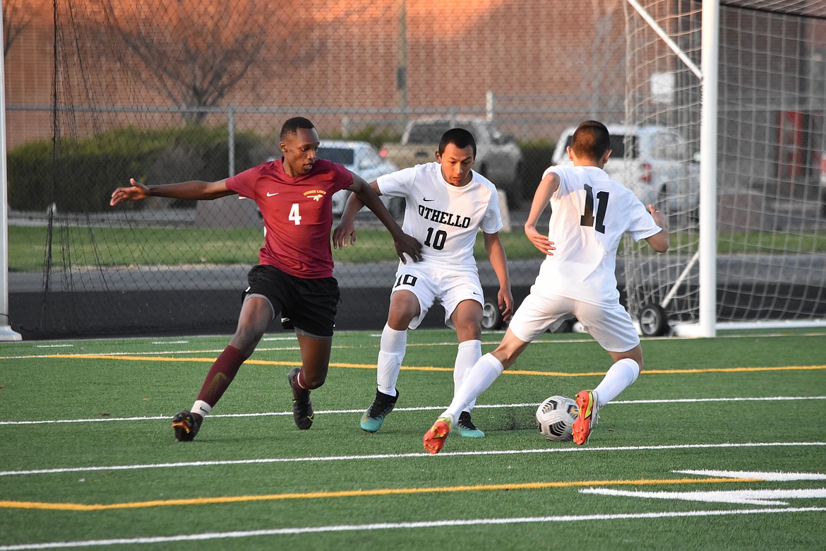 Othello High School freshman Jose Cabrera (10) guards Moses Lake High School senior Peter Nganga (4), while Othello sophomore Felipe Haro (11) moves the ball during the non-league matchup at Moses Lake on March 31.