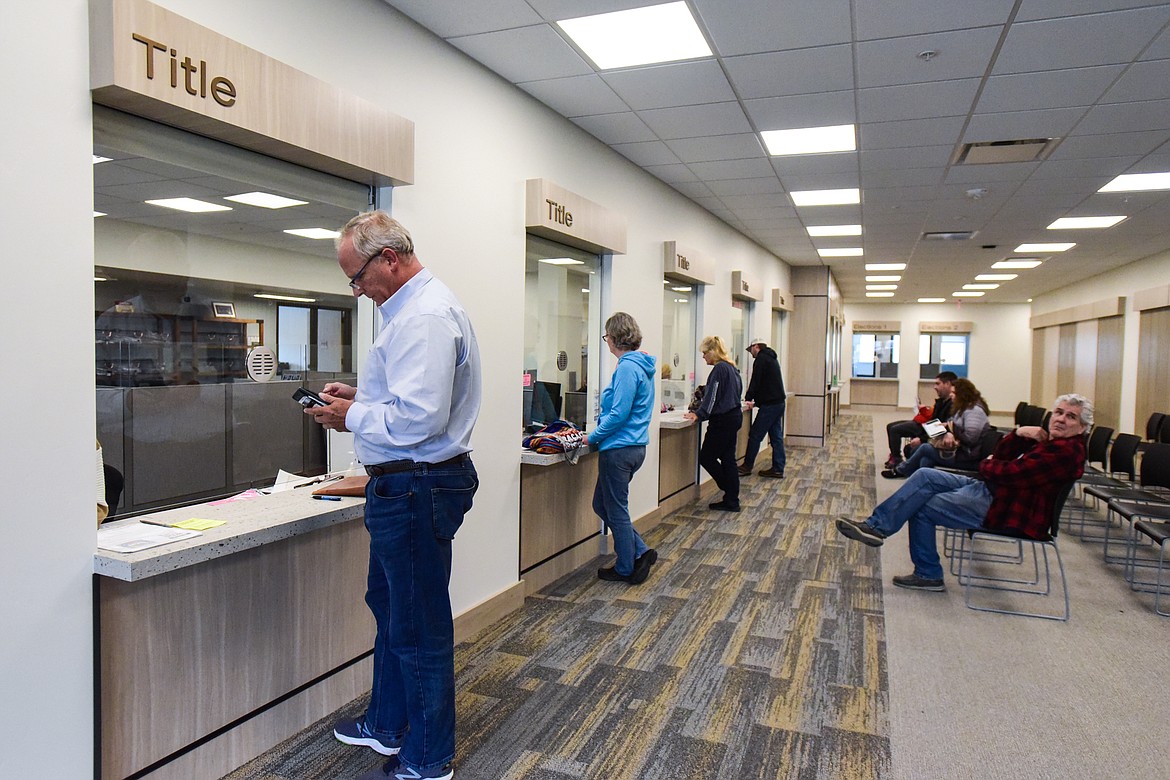 Customers stand at windows in the county treasurer's office inside the new North Complex building in Kalispell on Wednesday, April 20. (Casey Kreider/Daily Inter Lake)