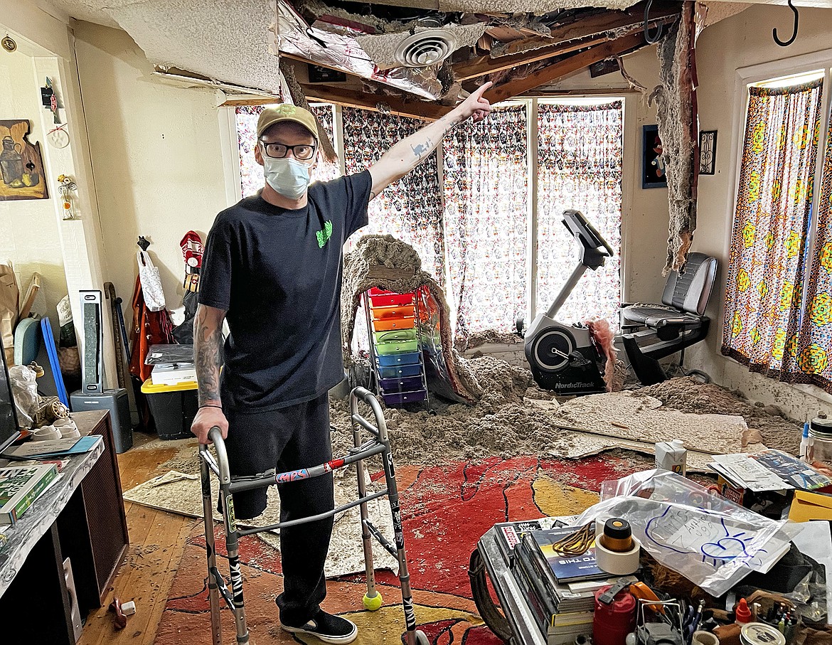 Kolby Zugg points to the damage done inside the house after a large tree fell on Lupfer Avenue Tuesday evening. (Photo courtesy of Lyndsay Schott)