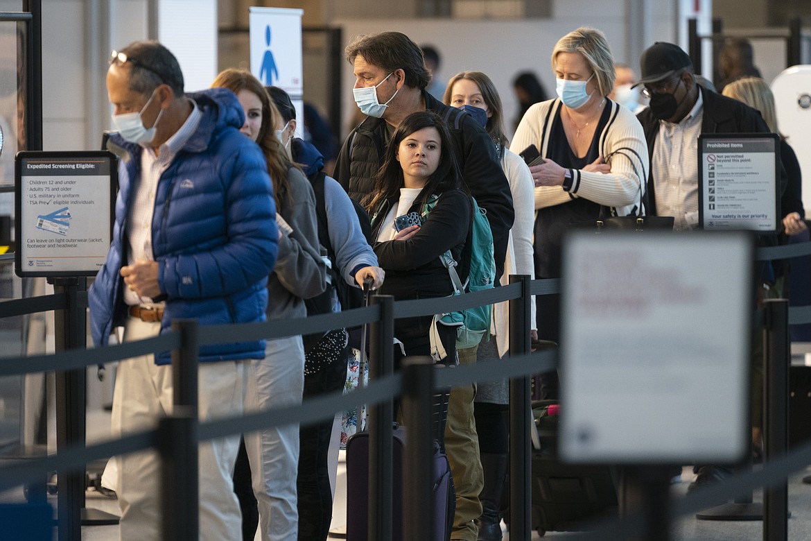 Passengers wait in line at the security checkpoint at Ronald Reagan Washington National Airport, Tuesday, April 19, 2022, in Arlington, Va. (AP Photo/Evan Vucci)