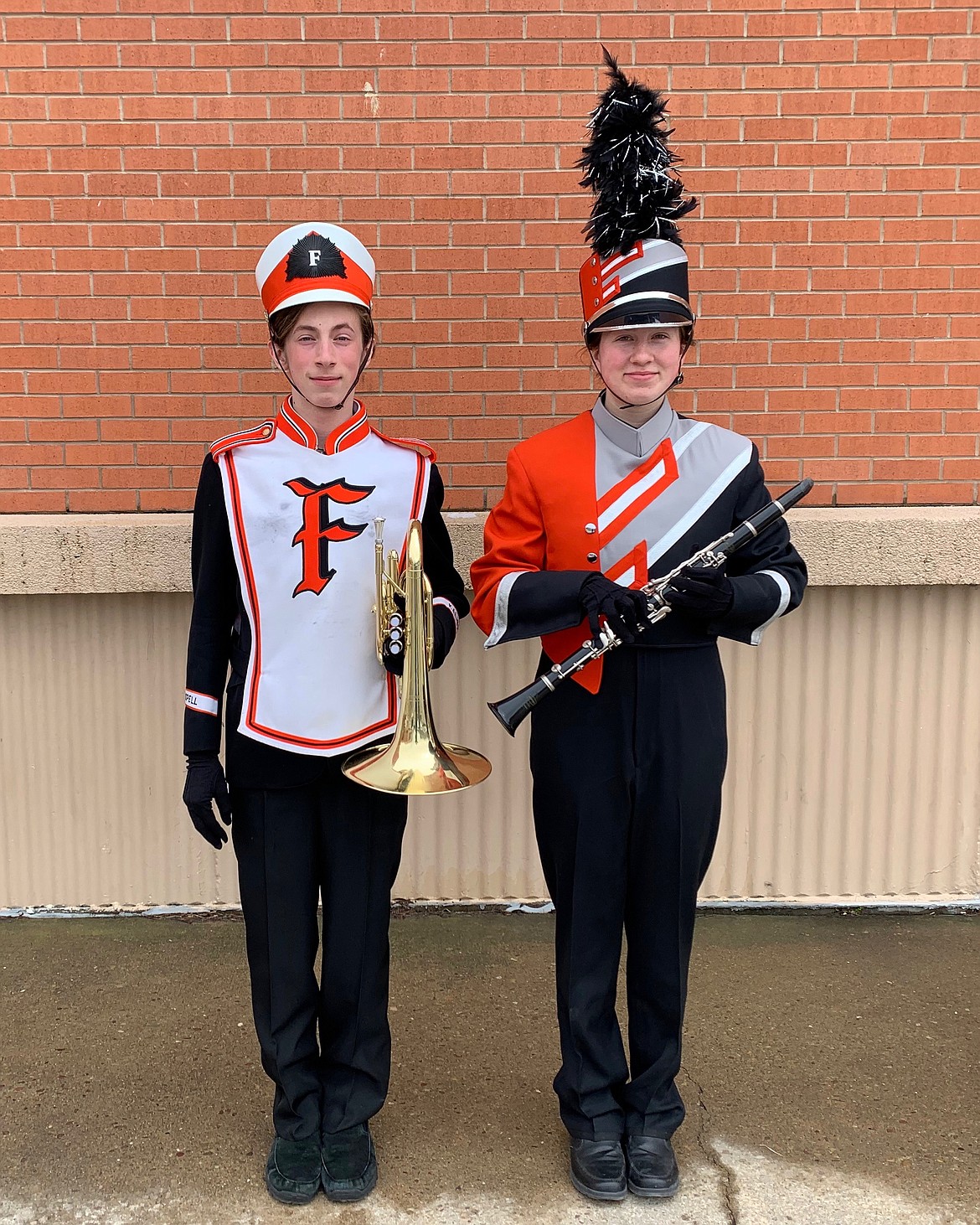 The Flathead High School marching band is set to get its first new uniforms in about 50 years. Students show the old uniform, left, next to the new design, right.
