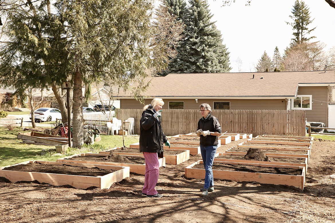 Nancy Mills, left, president of Shared Harvest Community Garden in Coeur d'Alene, and Jodi Foutch, vice president — donation garden, work in the garden on Wednesday to prepare for a community spring cleaning on Sunday. HANNAH NEFF/Press