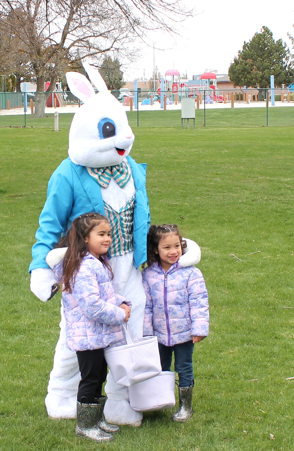 Kailana Dinh, 5, left, and her sister Nayva Dinh, pose for a photo with the Easter Bunny Saturday at McCosh Park during the annual Easter egg hunt sponsored by the Moses Lake Lions Club.