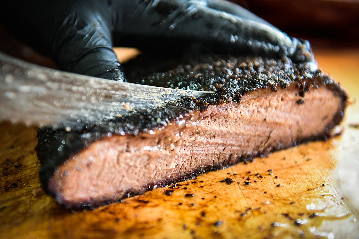 Arnold Mendez slices brisket inside the Arn's BBQ food truck in Kalispell on Wednesday, April 20. (Casey Kreider/Daily Inter Lake)