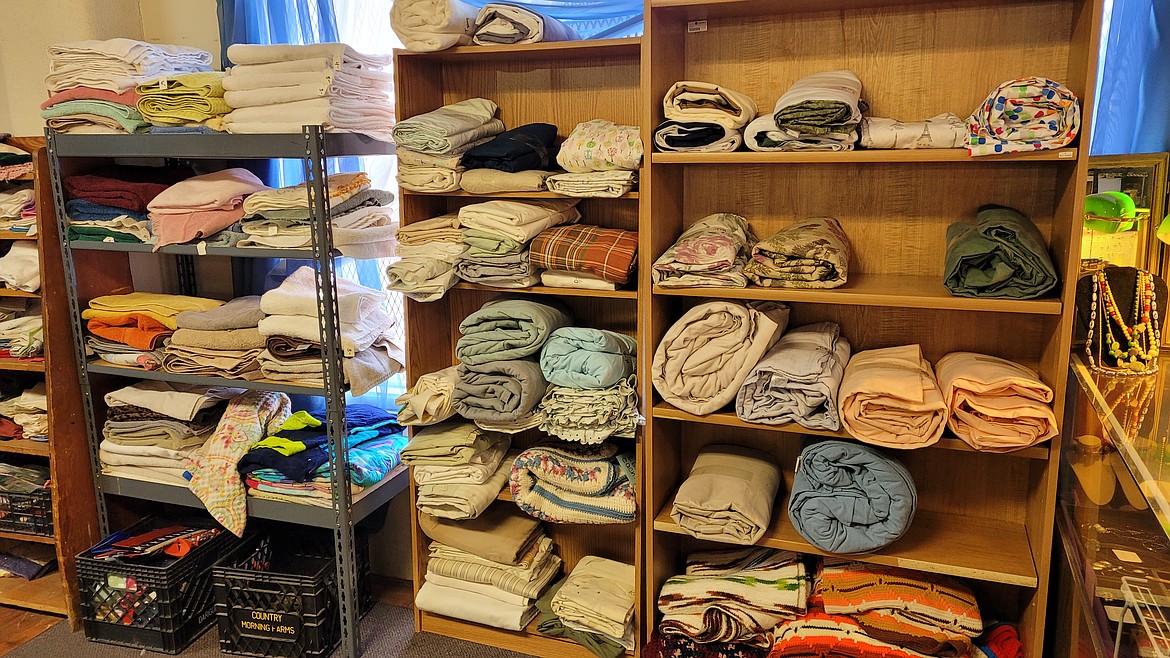 Georgie’s Gently Used offers a wide variety of linens and bedding for customers to select from. Each item is neatly folded and laid out for easy access.