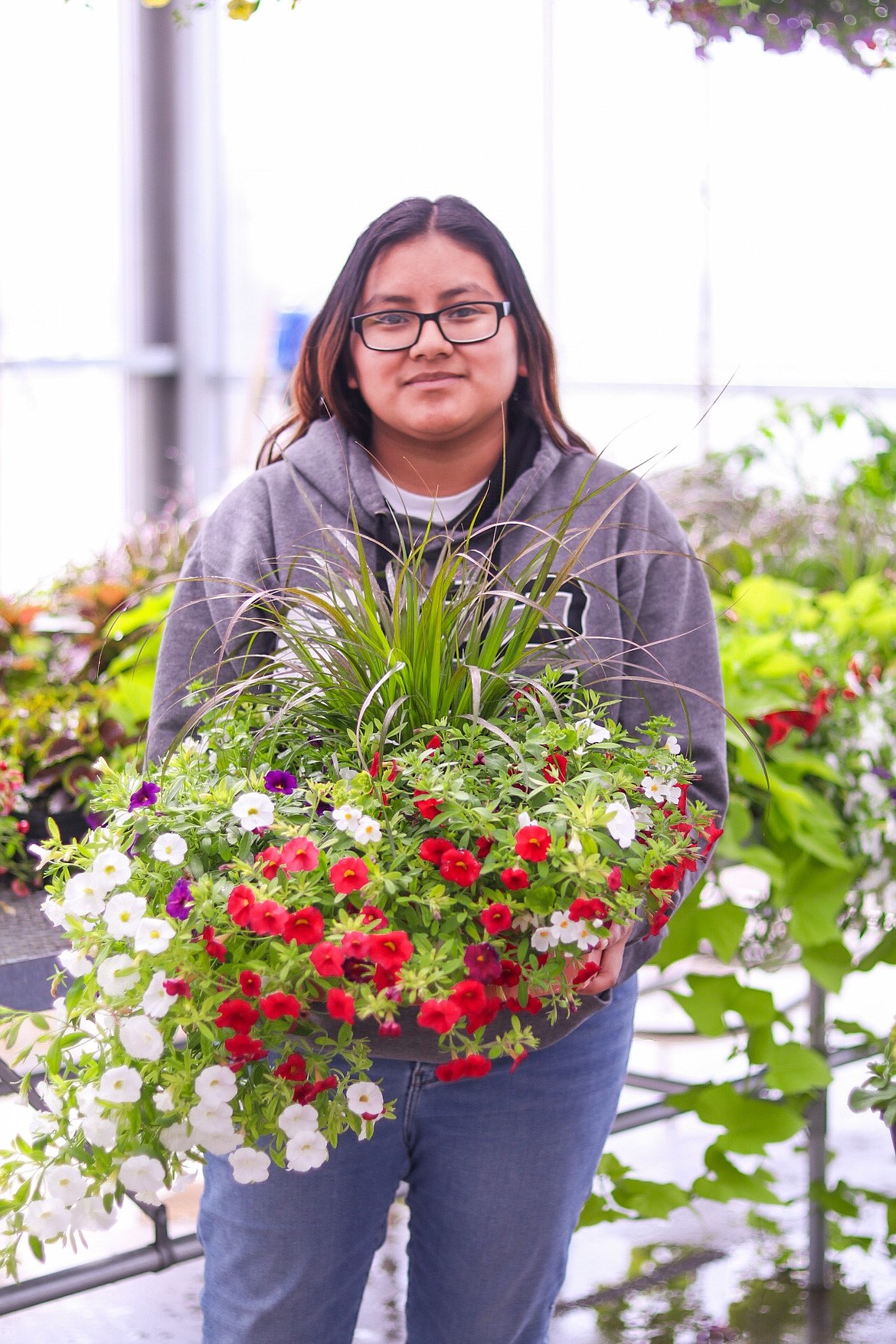 Quincy High School student and QHS FFA participant Nicole Barnett displays a flower-filled basket designed and planted by students in the QHS greenhouse.