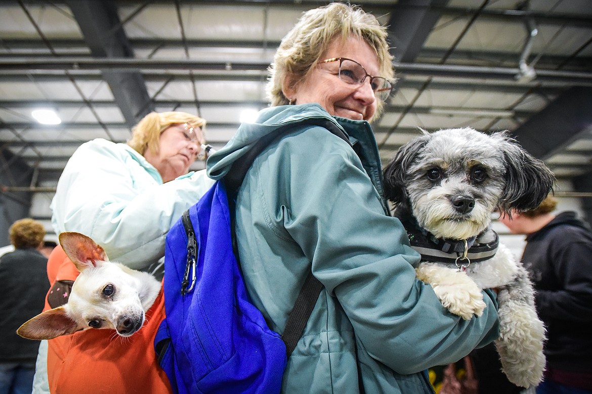 Judene Ness, left, fills out a form on the shoulder of her sister Jolene Benker as they carry their dogs Lucy, left, a Chihuahua/whippet mix, and Willow, a mini Austrian shepherd/poodle mix around the Flathead Kennel Club Canine Expo at the Flathead County Fairgrounds Trade Center on Saturday, April 23.(Casey Kreider/Daily Inter Lake)