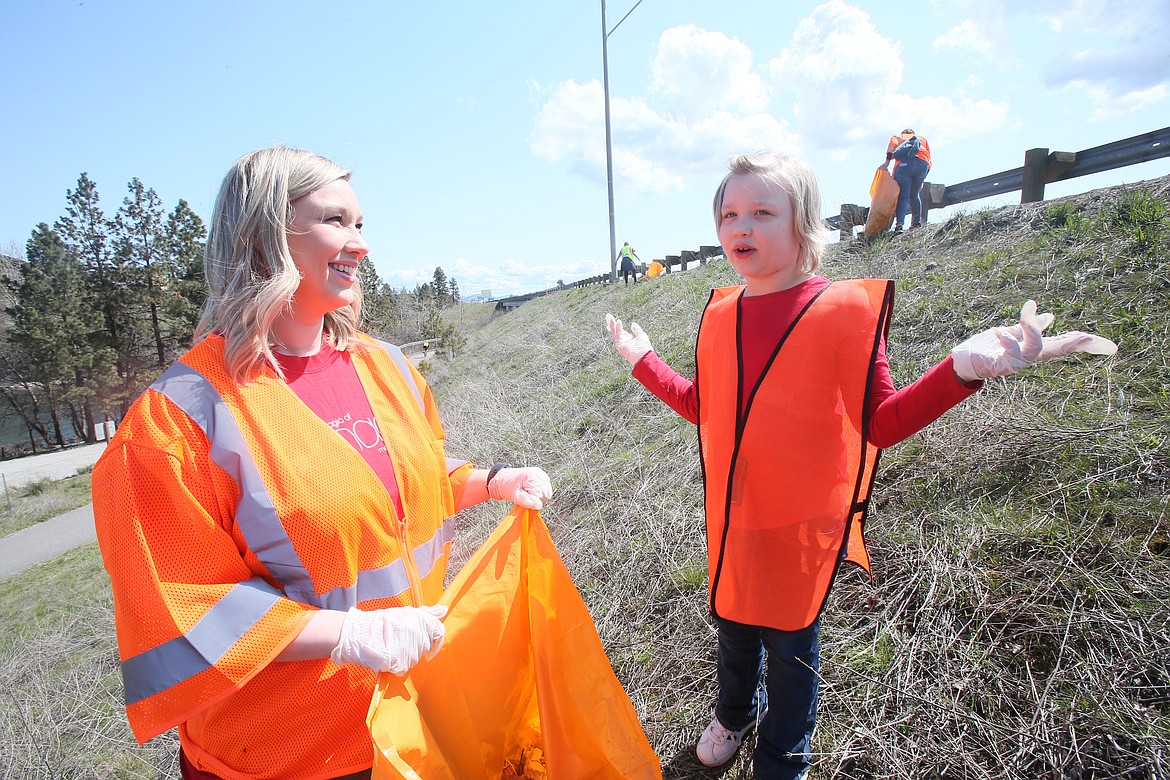 Savannah Shoot, 7, discusses her objective to keep Earth clean and healthy as she and her mom, Sarah Shoot, pick up trash along I-90 near the Washington border on Sunday.