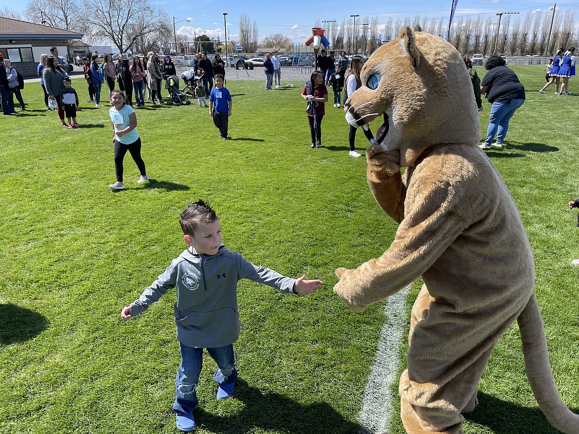 Warden Cougar mascot Cason Cox gives a high-five to a Warden Elementary School student near the end of the school’s annual jog-a-thon fundraiser on Friday.