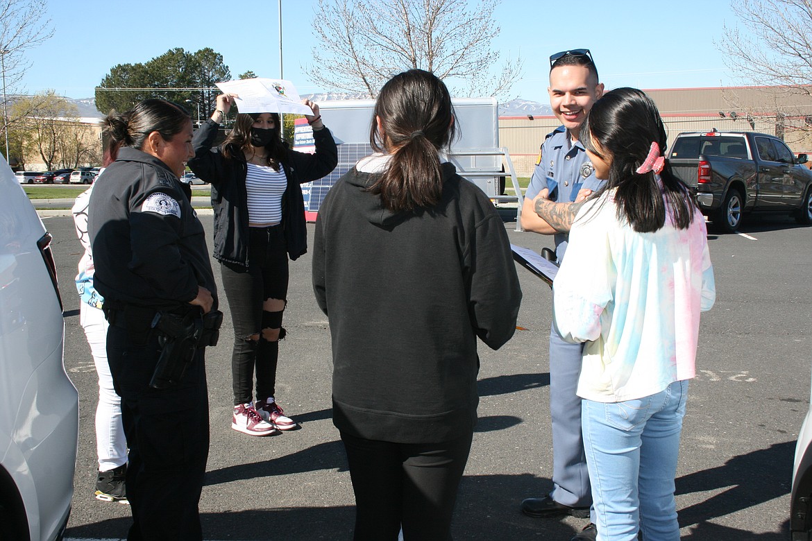 Washington State Patrol troopers Mireya Antunez (left) and Bryan Villaneuva (right) talk with students during Wahluke High School’s Outdoor Career Fair.