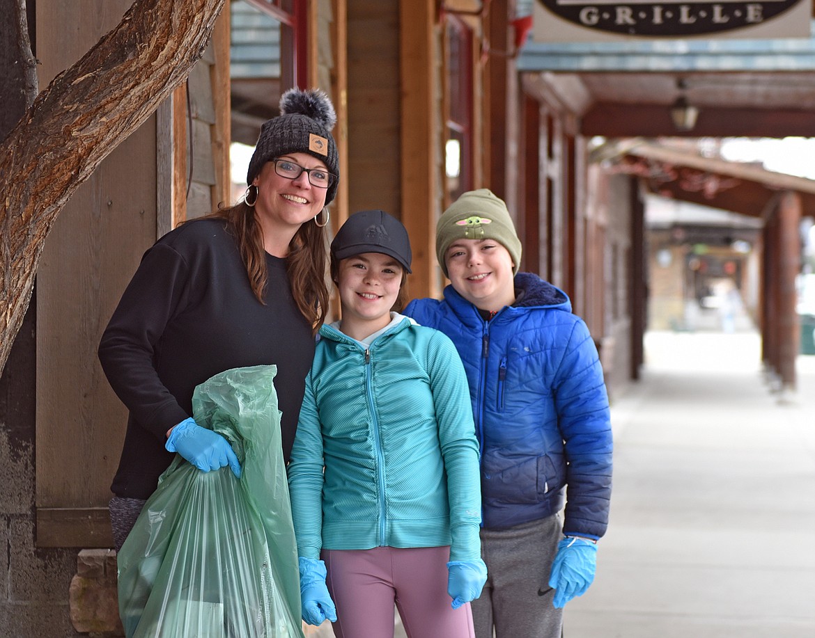 Katie Akey, Will Harris and Hayden Harris help to Clean the Fish along Central Avenue Saturday. (Julie Engler/Whitefish Pilot)