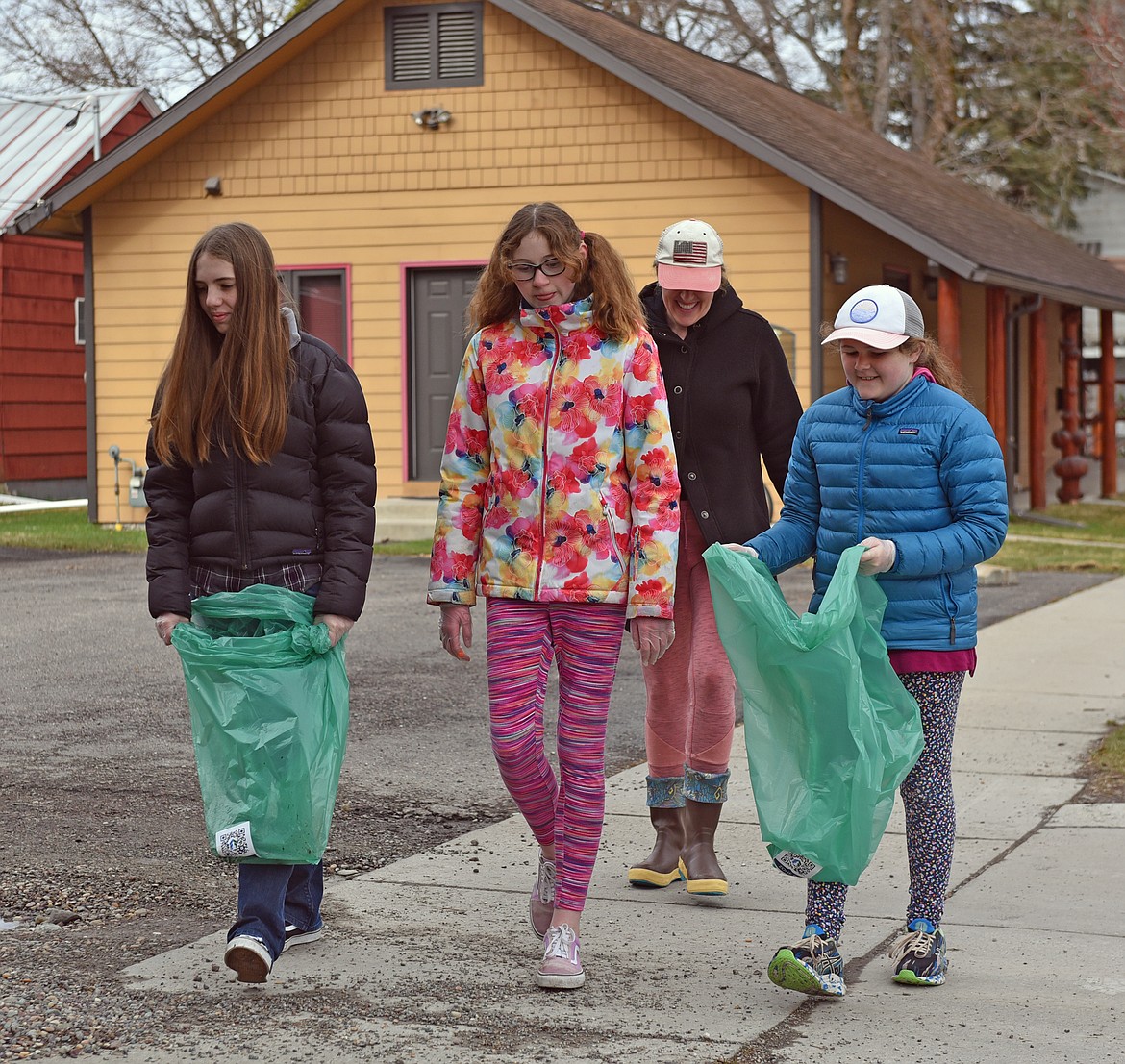 Ada Rose Petersen, Edolie Petersen, Tori Tamm and Angie Petersen help to Clean the Fish along Fifth Street Saturday. (Julie Engler/Whitefish Pilot)