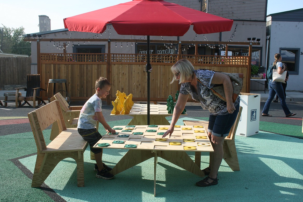 Hayden Darnell and his mom Annette Darnell play checkers during the Quincy Farmers Market on B Street in September 2021. The Quincy City Council will hold a public hearing on making traffic changes to one block of B Street at its May 3 meeting.