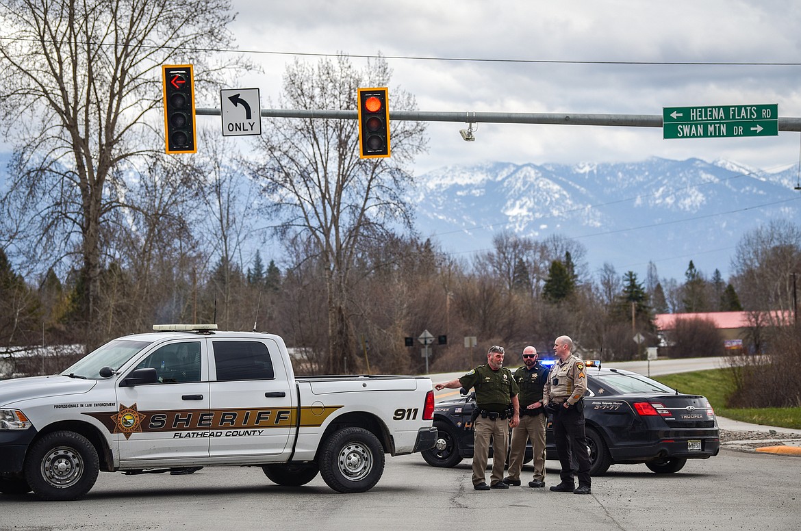 Deputies with the Flathead County Sheriff's Office and state troopers with Montana Highway Patrol block Highway 35 at Helena Flats Road and Swan Mountain Drive during an alleged incident involving SWAT near the bridge over the Flathead River on Tuesday, April 26. (Casey Kreider/Daily Inter Lake)