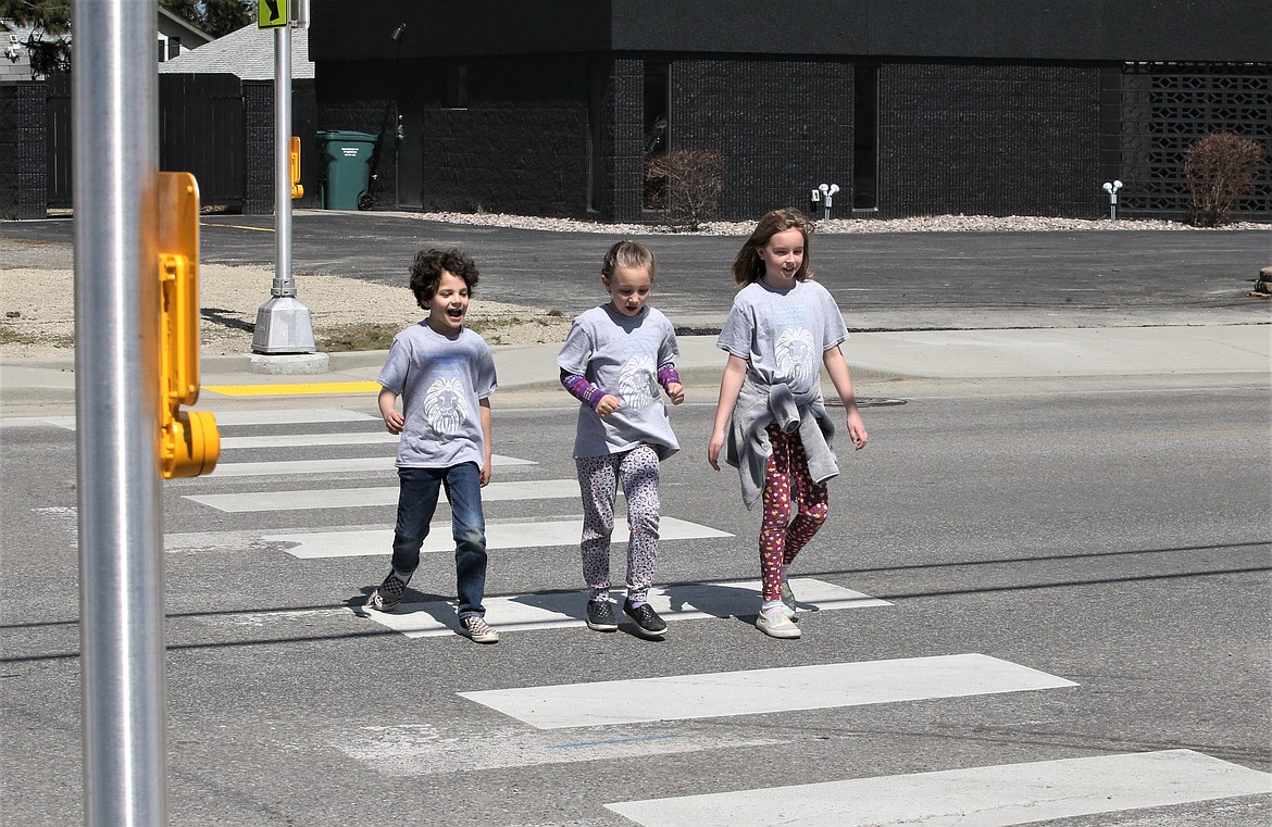 Borah Elementary students cross at Seventh and Best on Friday, where new flashing pedestrian lights were installed by the city. From left, Korben Barber-Thomas, Timberlynn Davies and Emerson Moffatt.