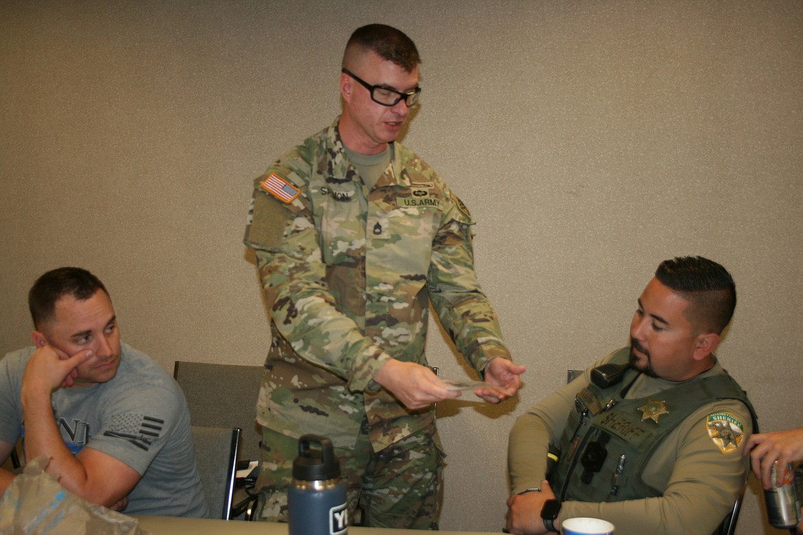 Sergeant first class Scott Salmon hands out an example of a fentanyl pill to Adams County Sheriff’s deputies.