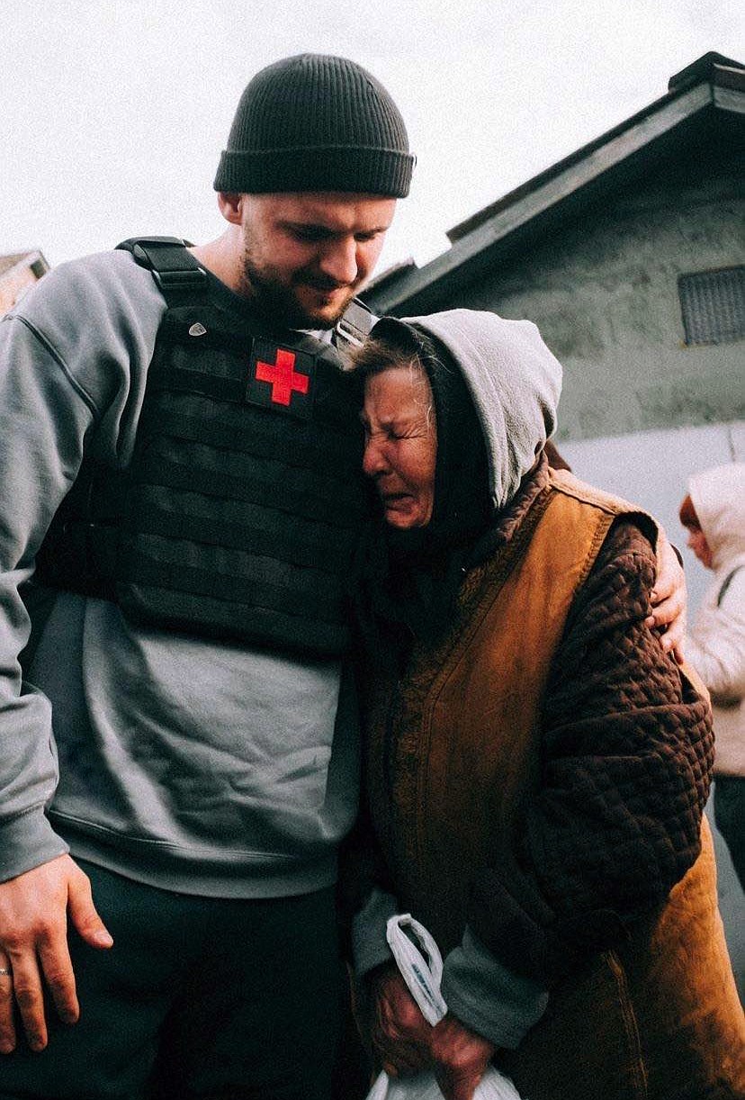 A volunteer comforts an elderly woman after delivering supplies in the Ukraine capital city of Kyiv. (photo provided)