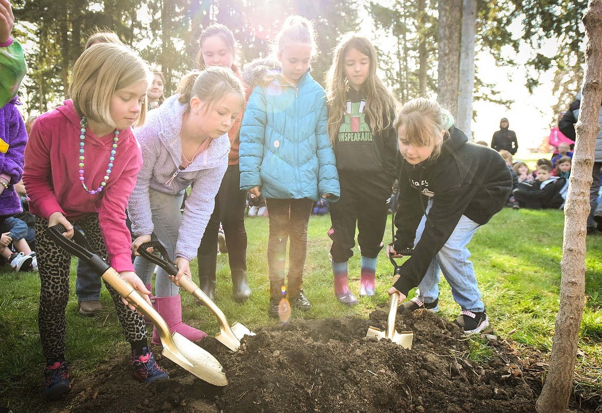 Third-grade students shovel dirt as an Ohio buckeye tree is planted during the Arbor Day celebration at Woodland Park in Kalispell on Friday, April 29. (Casey Kreider/Daily Inter Lake)