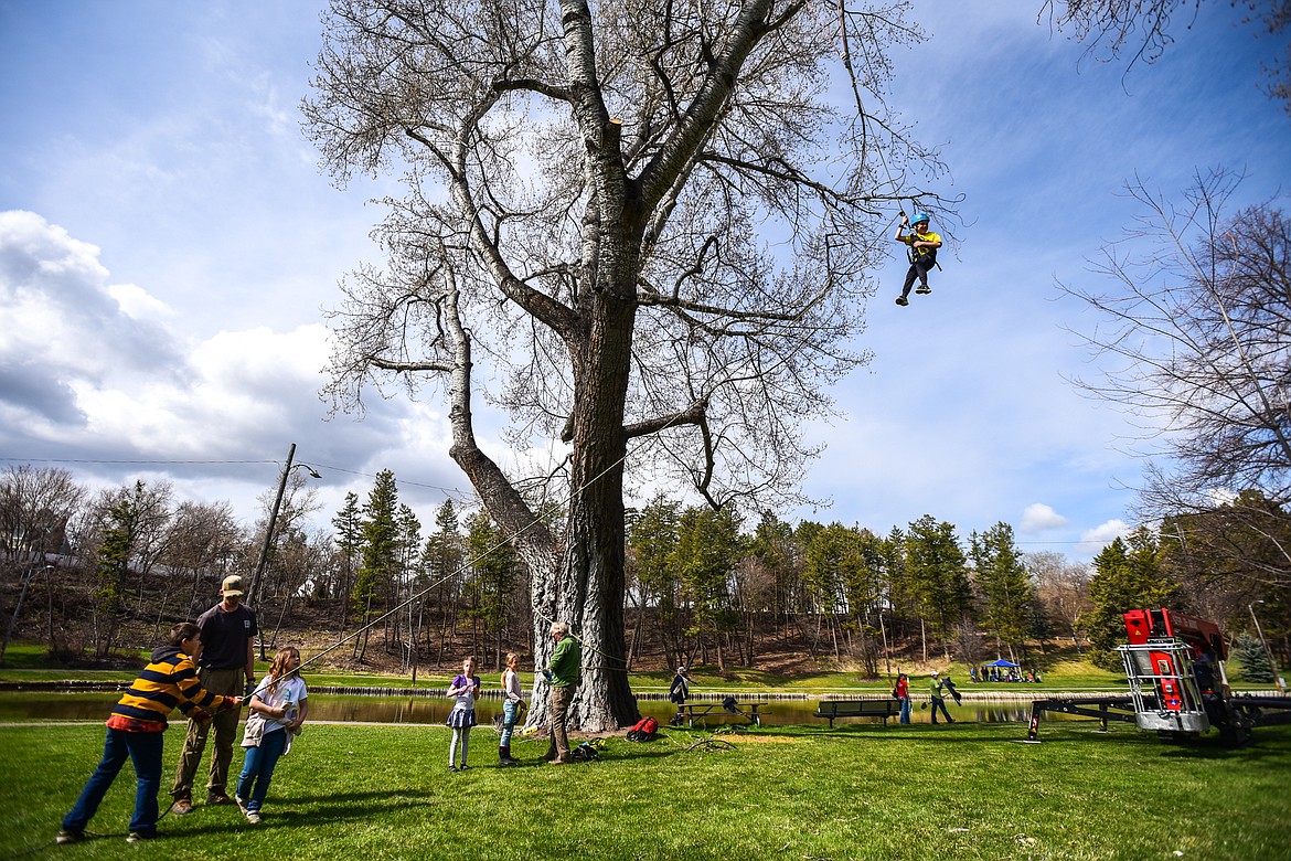 Edgerton Elementary third-grader Masen Reithmeier is harnessed in and hoisted into the canopy of a tree by arborists from Trees for Life Montana during the Arbor Day celebration at Woodland Park in Kalispell on Friday, April 29. (Casey Kreider/Daily Inter Lake)