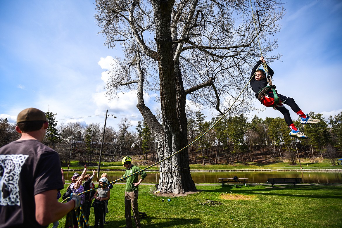 Edgerton Elementary third-grader Kellen Bigelow is harnessed in and hoisted into the canopy of a poplar tree by arborists from Trees for Life Montana during the Arbor Day celebration at Woodland Park in Kalispell on Friday, April 29. (Casey Kreider/Daily Inter Lake)