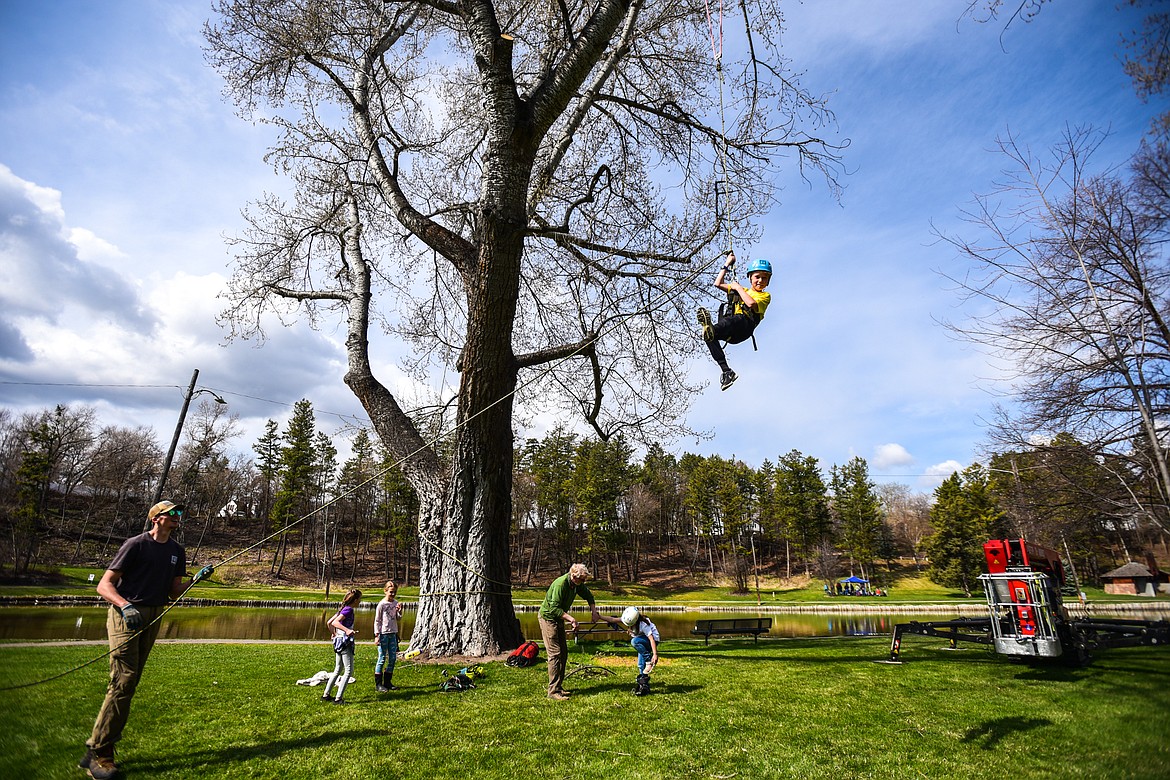 Edgerton Elementary third-grader Masen Reithmeier is harnessed in and hoisted into the canopy of a tree by arborists from Trees for Life Montana during the Arbor Day celebration at Woodland Park in Kalispell on Friday, April 29. (Casey Kreider/Daily Inter Lake)
