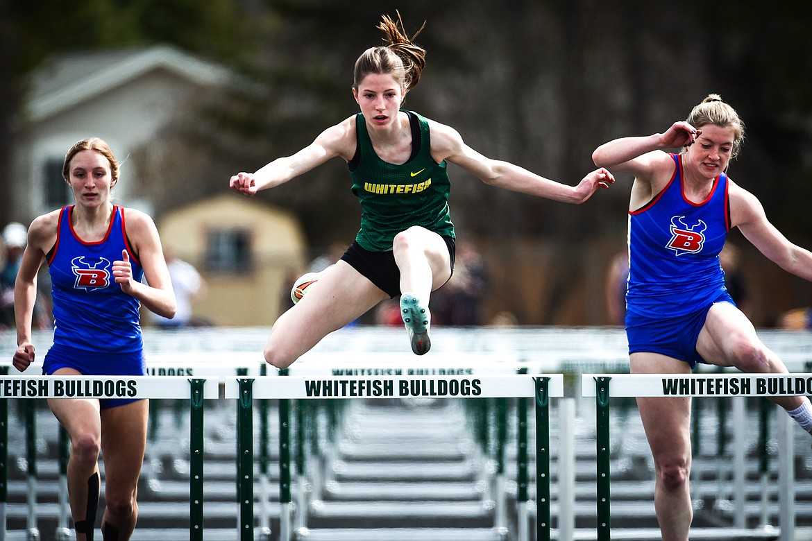 Whitefish's Hailey Ells clears a hurdle in the girls 100 meter hurdles at the Whitefish ARM Invitational on Saturday, April 30. On her left and right are Bigfork's Inga Turner and Lily Tanko. (Casey Kreider/Daily Inter Lake)