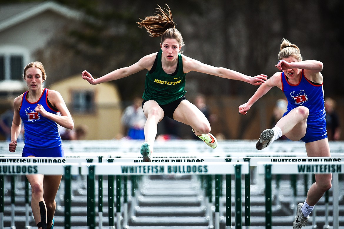 Whitefish's Hailey Ells clears a hurdle in the girls 100 meter hurdles at the Whitefish ARM Invitational on Saturday, April 30. On her left and right are Bigfork's Inga Turner and Lily Tanko. (Casey Kreider/Daily Inter Lake)