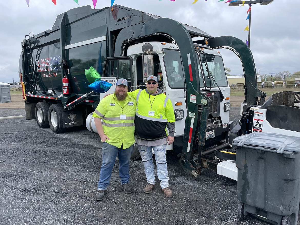 Lakeside Disposal and Recycling employees Jake Cooney (left) and Chris Longstreet pose with their company’s garbage truck, which was on display at the Moms of Preschoolers Touch-A-Truck fundraiser at Moses Lake Presbyterian Church on Saturday.