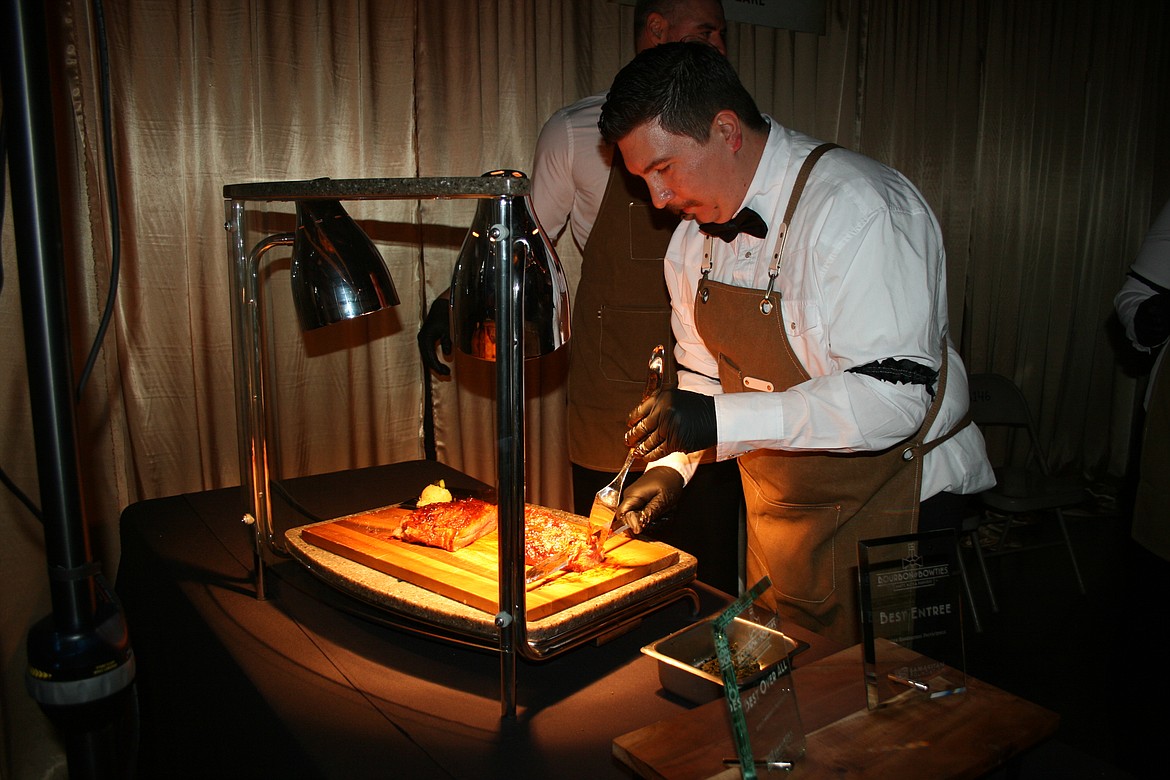 Porterhouse Steakhouse executive chef Richard Paulk slices the tri-tip for plating during the Bourbon & Bowties fundraiser Friday.