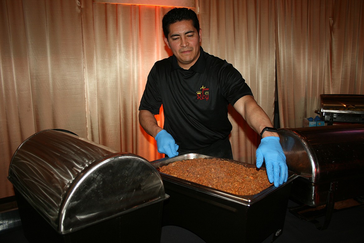 Tacos El Rey owner Enrique Campos prepares to serve during the Bourbon & Bowties fundraiser Friday.