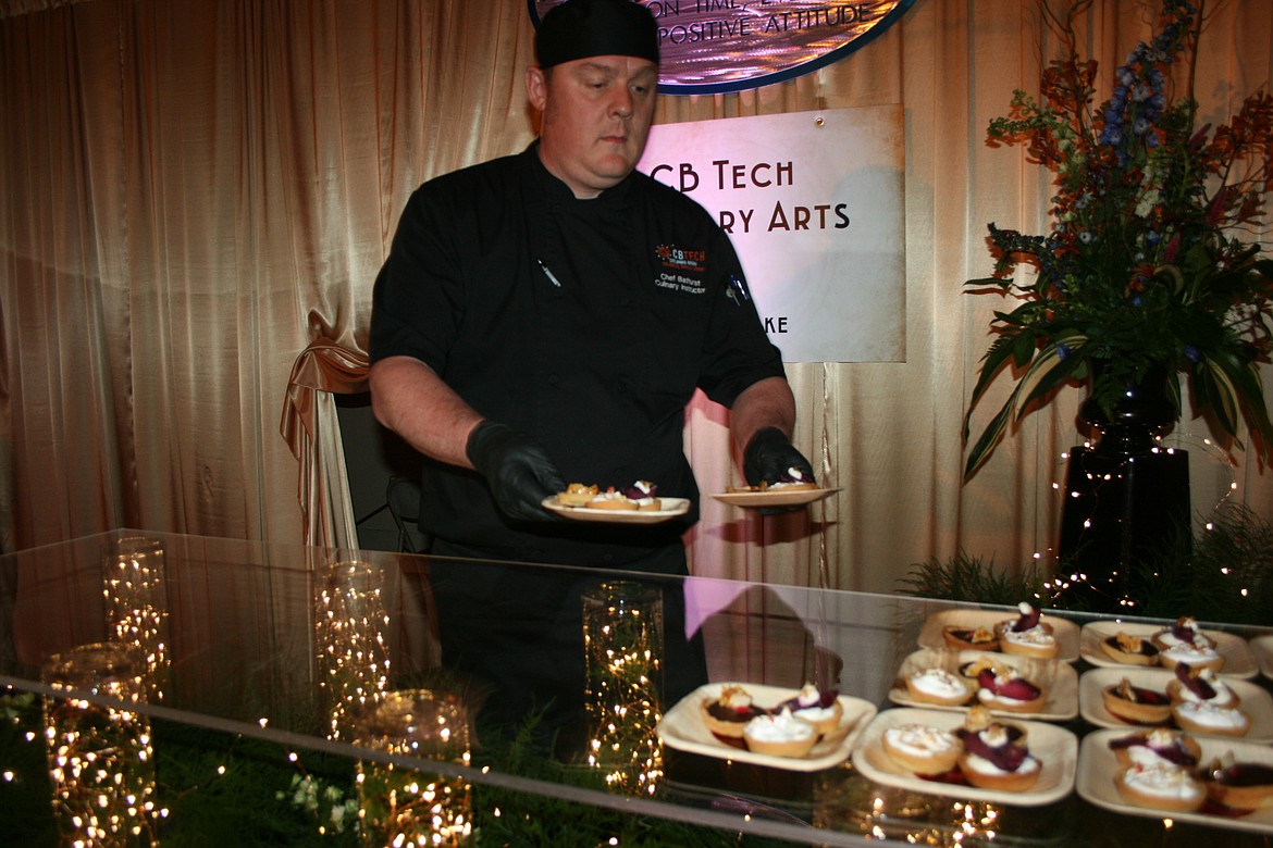 Columbia Basin Technical Skills Center culinary instructor Nathan Bathurse sets out desserts during the Bourbon & Bowties fundraiser.