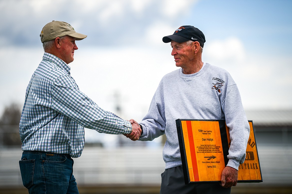 Flathead boys track and field coach Dan Hodge, right, is presented with a plaque by Derek Schulz, Flathead High class of 1985 and a former track and field athlete under Hodge, before a triangular meet with Missoula Hellgate and Missoula Sentinel at Legends Stadium on Tuesday, May 3. (Casey Kreider/Daily Inter Lake)