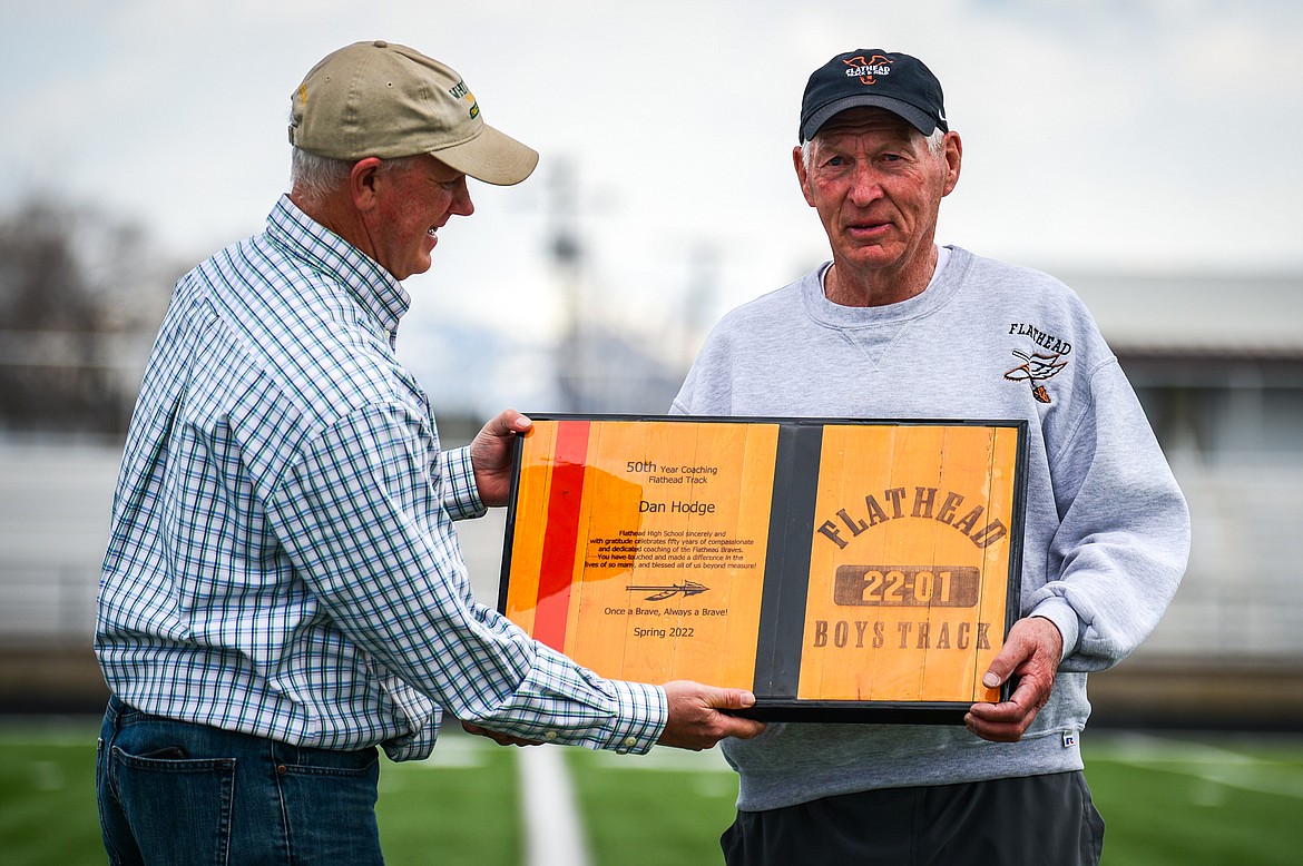 Flathead boys track and field coach Dan Hodge, right, is presented with a plaque by Derek Schulz, Flathead High class of 1985 and a former track and field athlete under Hodge, before a triangular meet with Missoula Hellgate and Missoula Sentinel at Legends Stadium on Tuesday, May 3. (Casey Kreider/Daily Inter Lake)