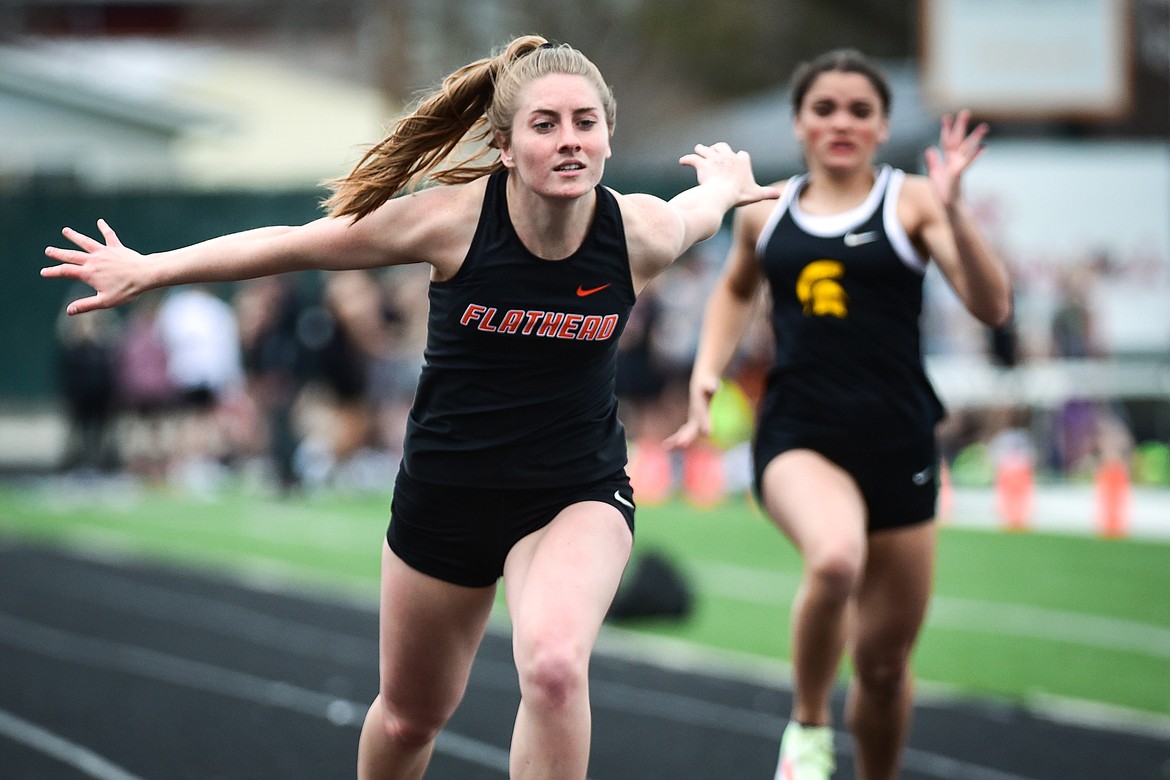 Flathead's Kelcey Copping leans in near the finish line in the girls 100 meter dash during a triangular meet with Missoula Hellgate and Missoula Sentinel at Legends Stadium on Tuesday, May 3. (Casey Kreider/Daily Inter Lake)