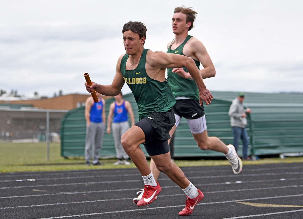 Whitefish's Ryder Barinowski gets the baton from Bodie Smith during the boys 4X100 relay at the Whitefish ARM meet on Saturday. (Whitney England/Whitefish Pilot)