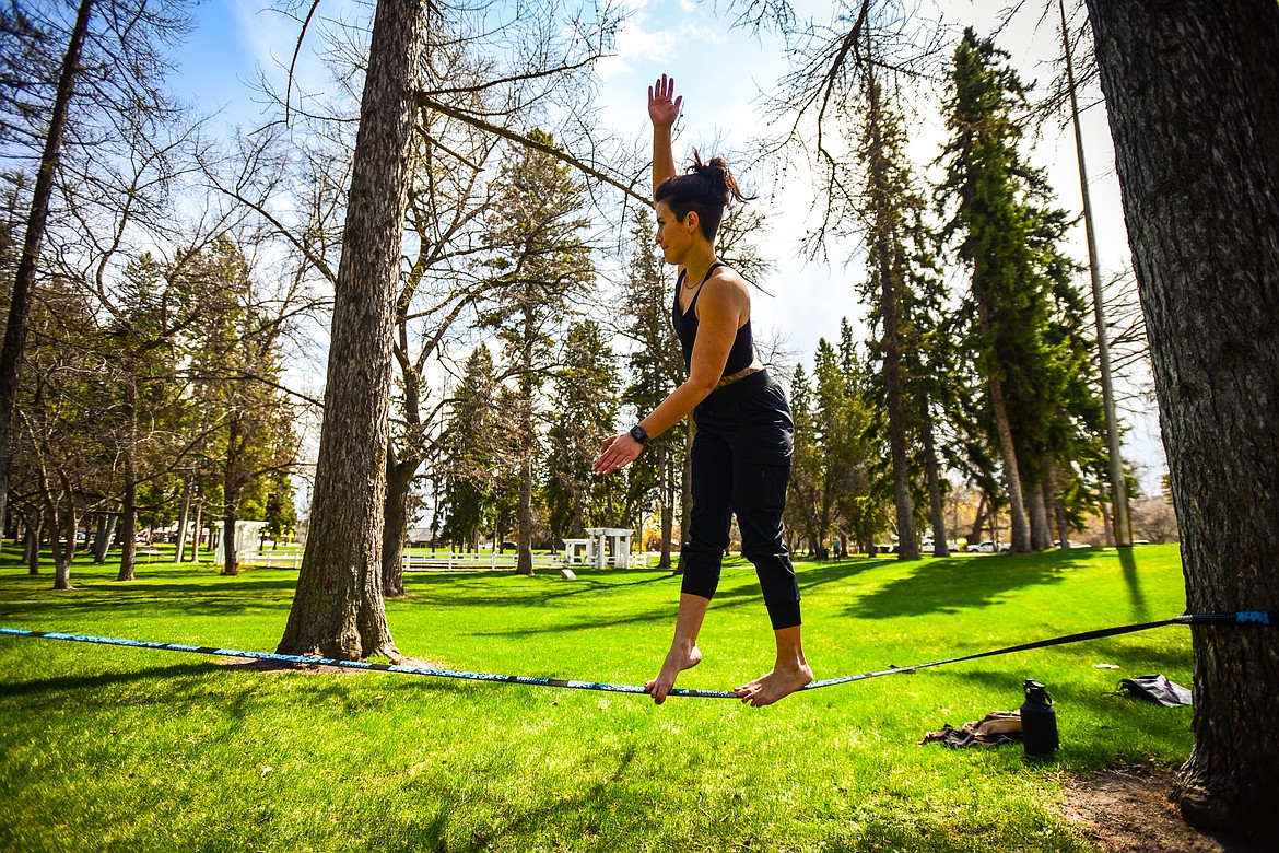 Christine Stratton balances on a slackline between two trees at Woodland Park in Kalispell on Friday, April 29. (Casey Kreider/Daily Inter Lake)