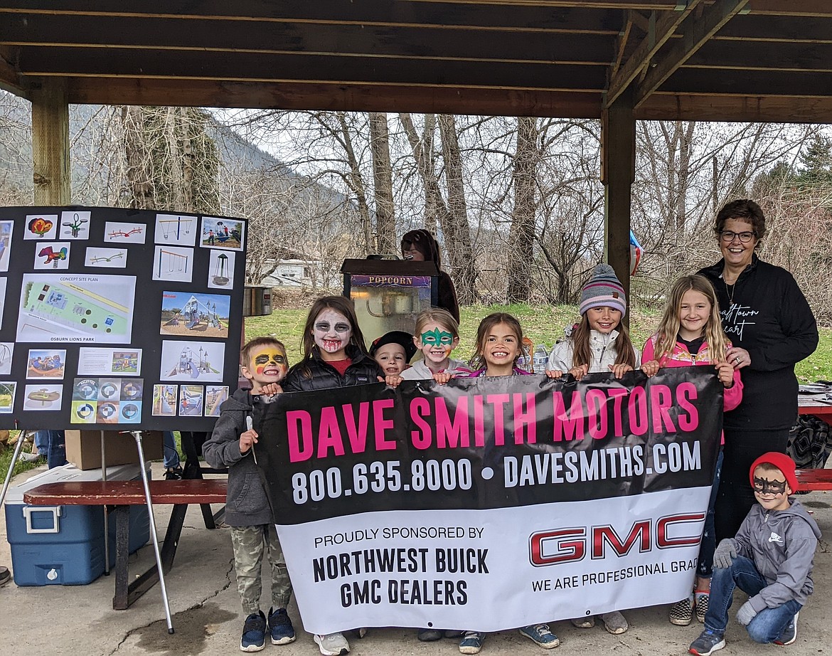 Marcy Hayman stands with children at the park thanking Dave Smith for their support.