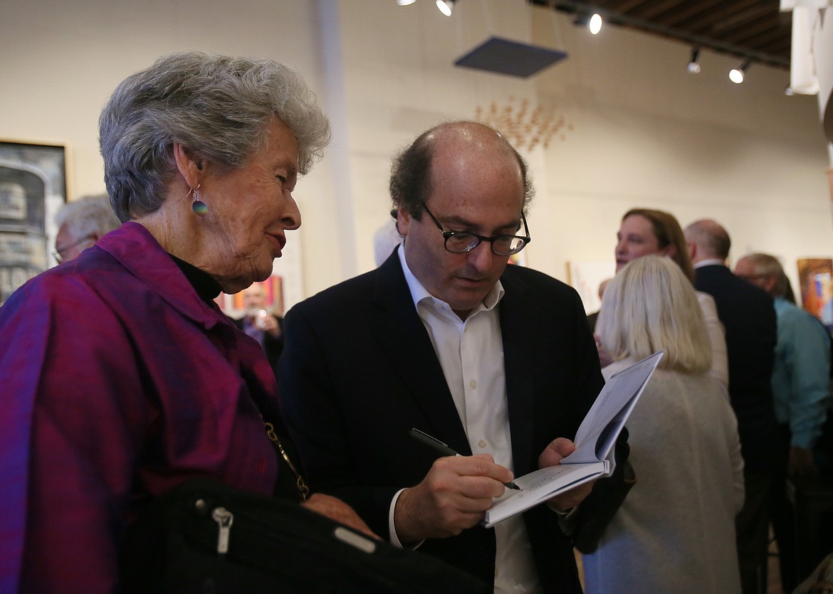 Best-selling author and award-winning journalist David Grann signs a book for Judy Meyer during a reception Friday evening in the Art Spirit Gallery ahead of the Idaho Humanities Council Dinner.