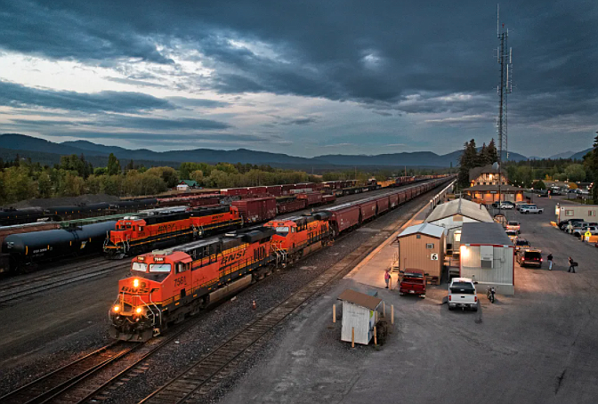 A BNSF Railway grain train departs Whitefish in September 2018, passing the office where train crews report for duty. (Credit: Justin Franz)