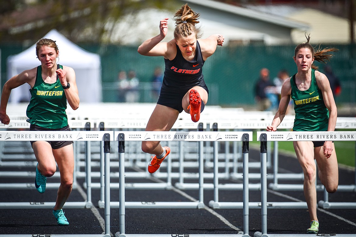 Flathead's Alivia Rinehart clears the final hurdle en route to a first place finish in the girls 100 meter hurdles at the Archie Roe Invitational track meet at Legends Stadium on Saturday, May 7. On the left and right of Rinehart are Whitefish's Maeve Ingelfinger and Hailey Ells. (Casey Kreider/Daily Inter Lake)