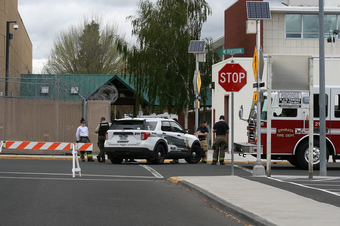 Grant County Sheriff’s Office and Ephrata Fire District personnel wait outside the Grant County Courthouse Friday afternoon, while the Washington State Patrol bomb squad evaluates a suspicious package.