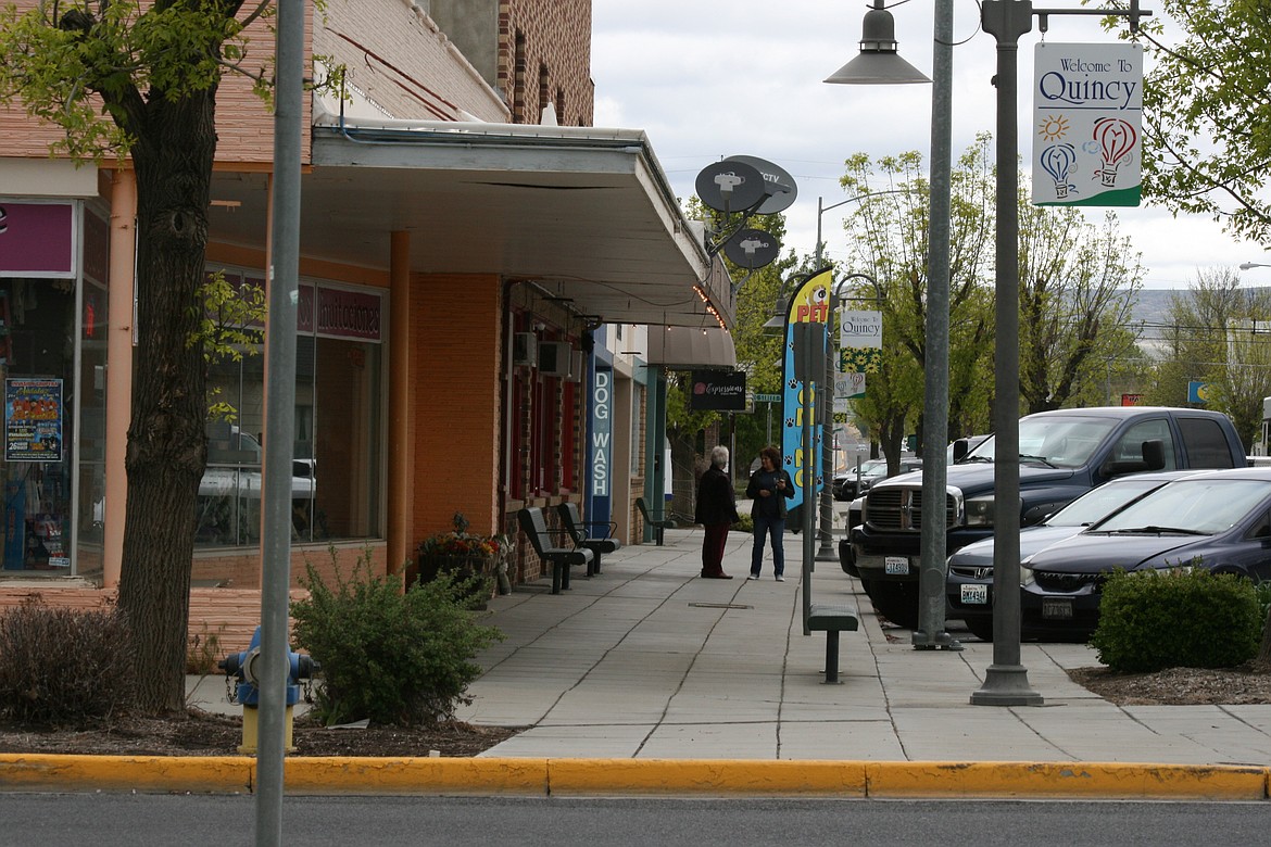 Pedestrians stop to talk on Central Avenue in downtown Quincy Friday. A draft downtown revitalization plan has been prepared and presented to the Quincy City Council. Residents will be able to comment on the plan at the next city council meeting.