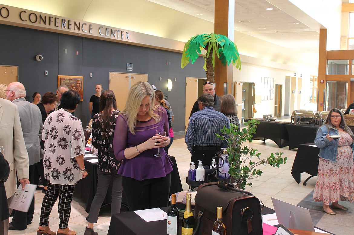 Trish Gwinn of Moses Lake looks over silent auction options at Cellarbration! For Education on Saturday evening. The fundraiser at Big Bend Community College brought in about $168,000 for student scholarships.