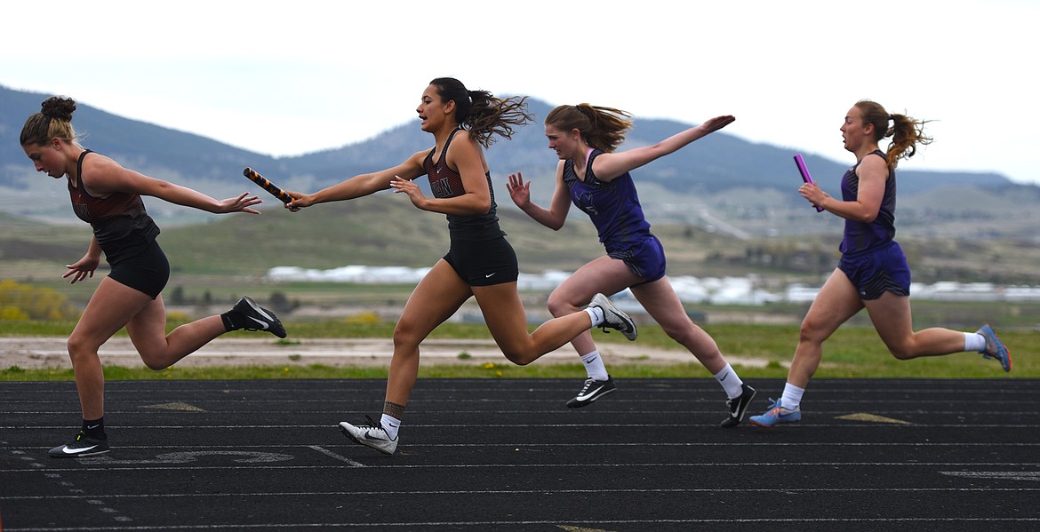 Ronan's Leina Ulutoa hands of the baton to Katie Dolance during the 4X100 relay as Charlo's Kyla Tomlin passes to Aida Cote. (Scot Heisel/Lake County Leader)